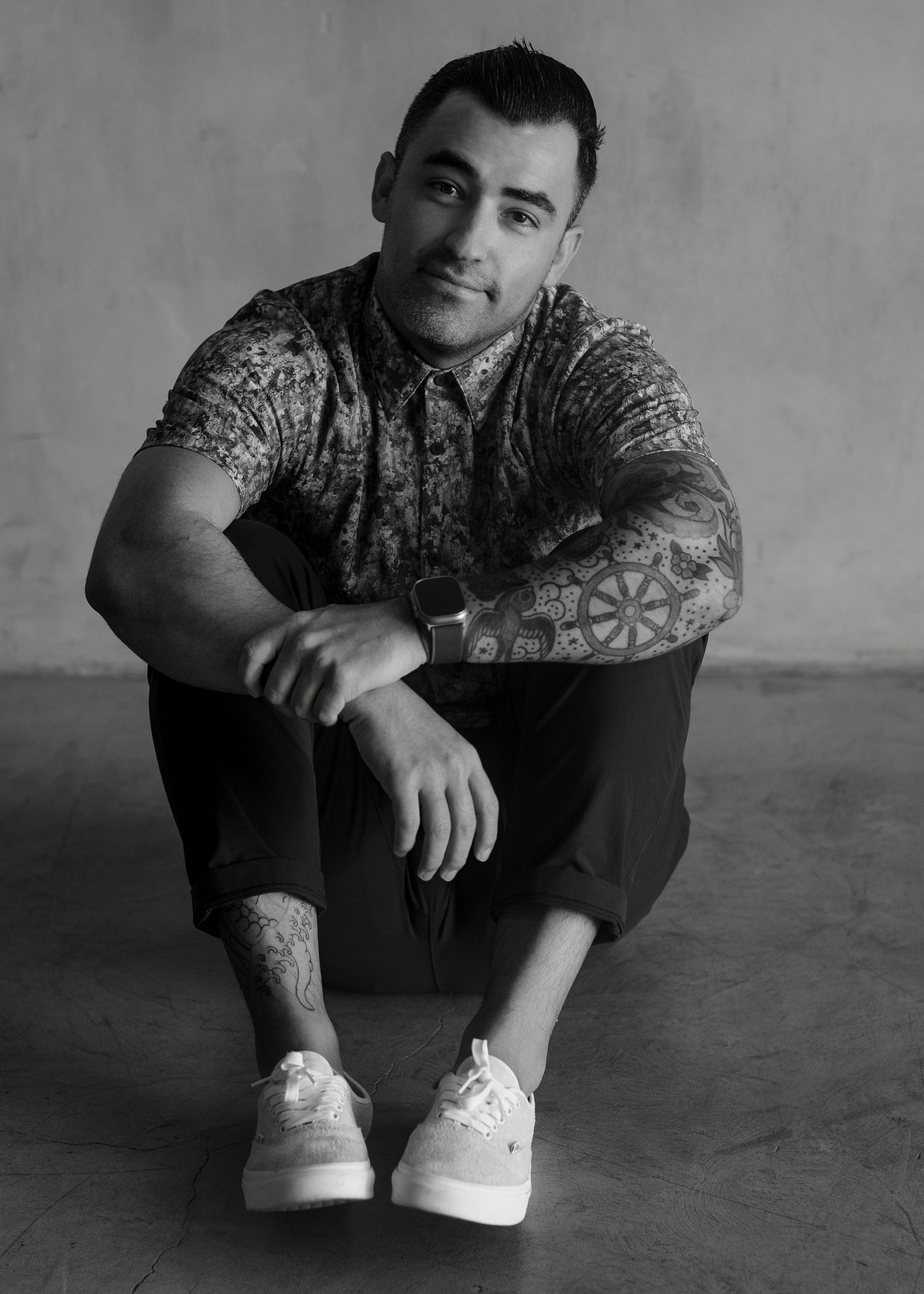Michael Astorga, a Southern California wedding photographer, holding a camera and smiling against a neutral backdrop.