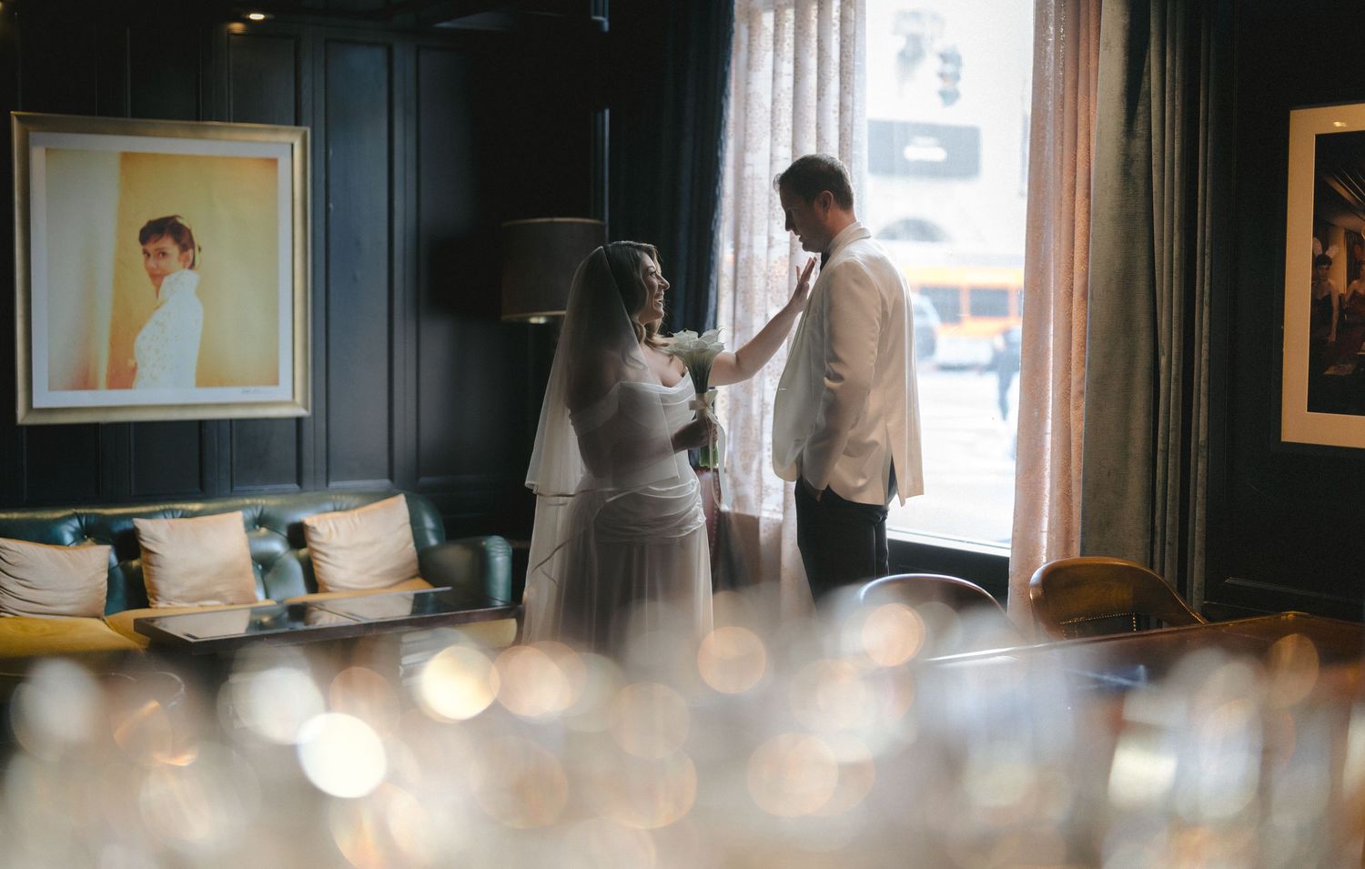 Bride and groom sharing intimate moment in stylish hotel suite before wedding.