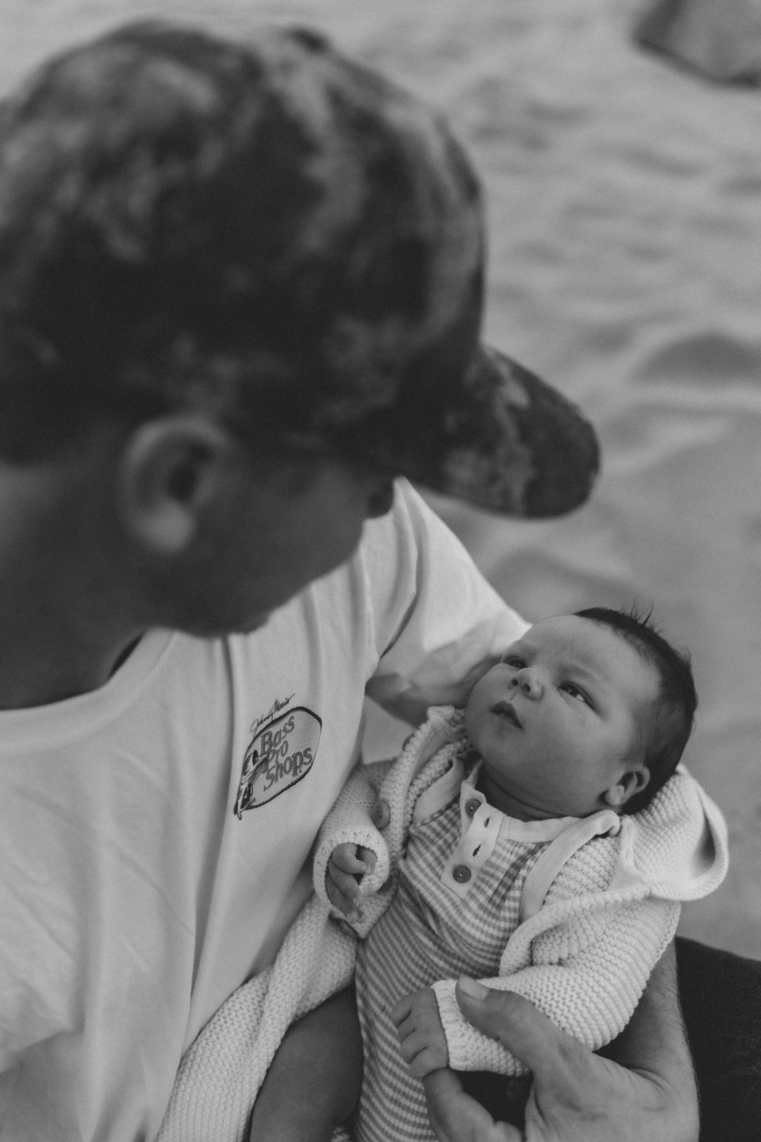 Black and white portrait of tender moments between dad and baby on the beach