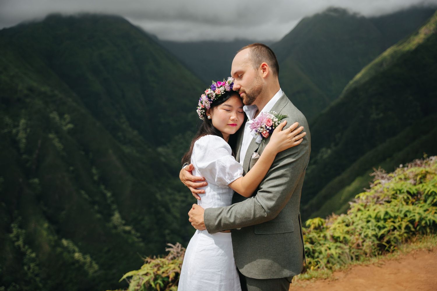 A romantic mountain elopement photoshoot with dramatic cloudy skies in the background.