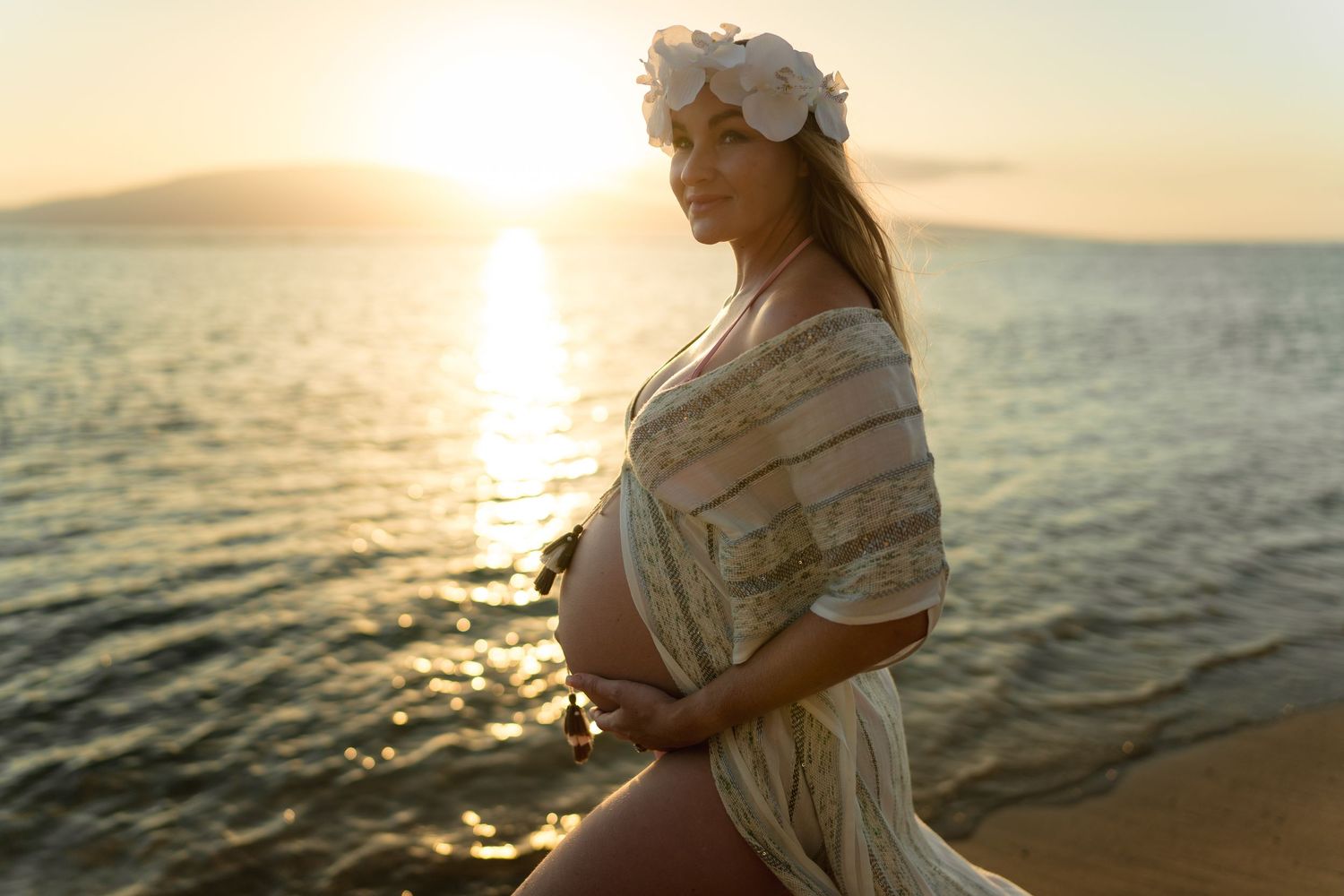 Elegant maternity portrait at beach during golden sunset.