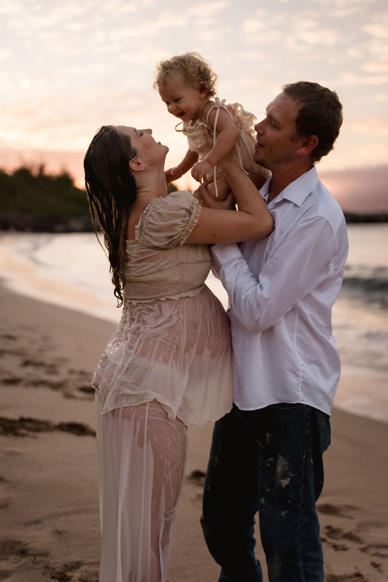 Romantic couple embracing and dancing on a beach at sunset.