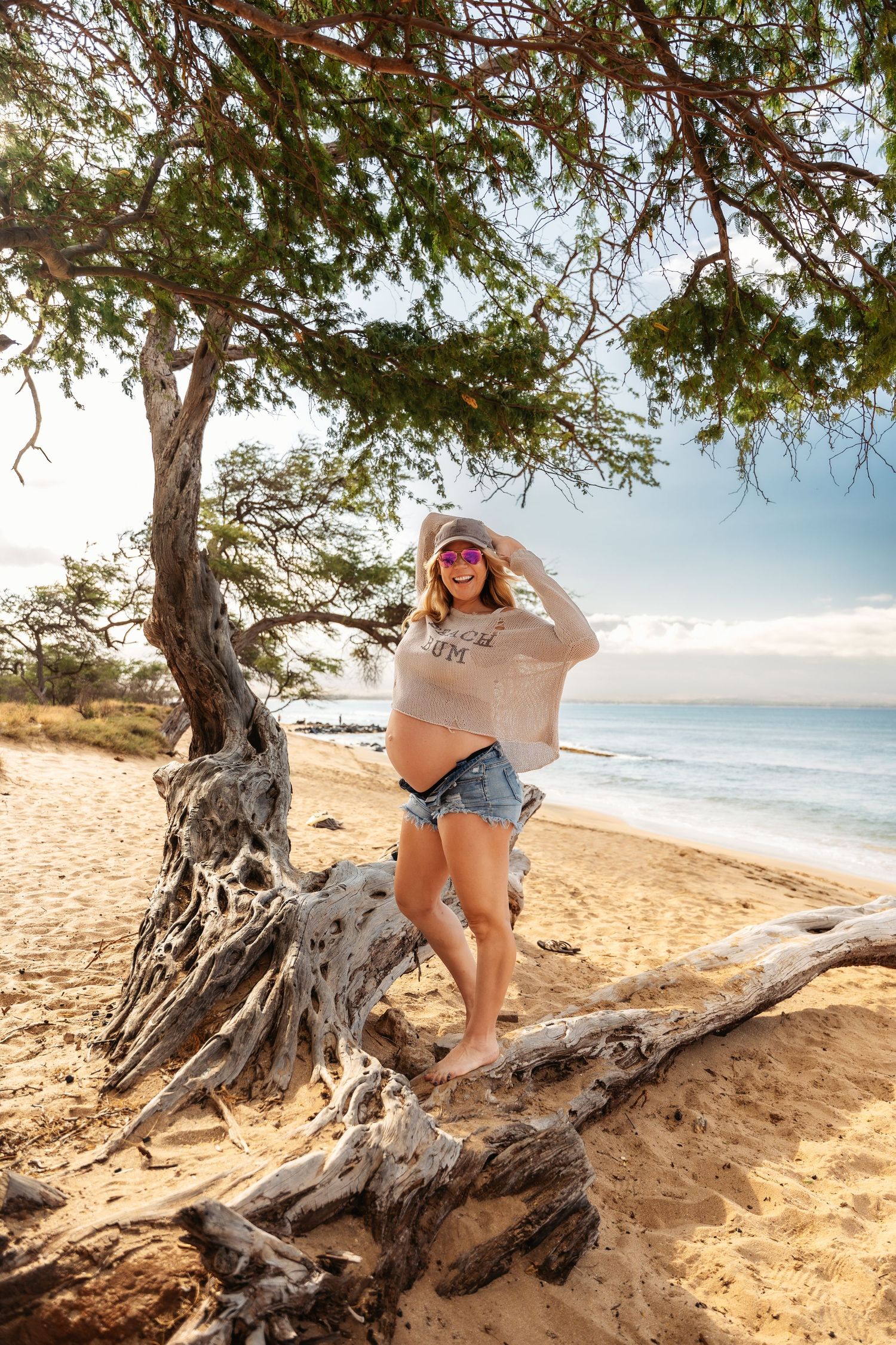 Relaxed beachside portrait on driftwood with ocean view.