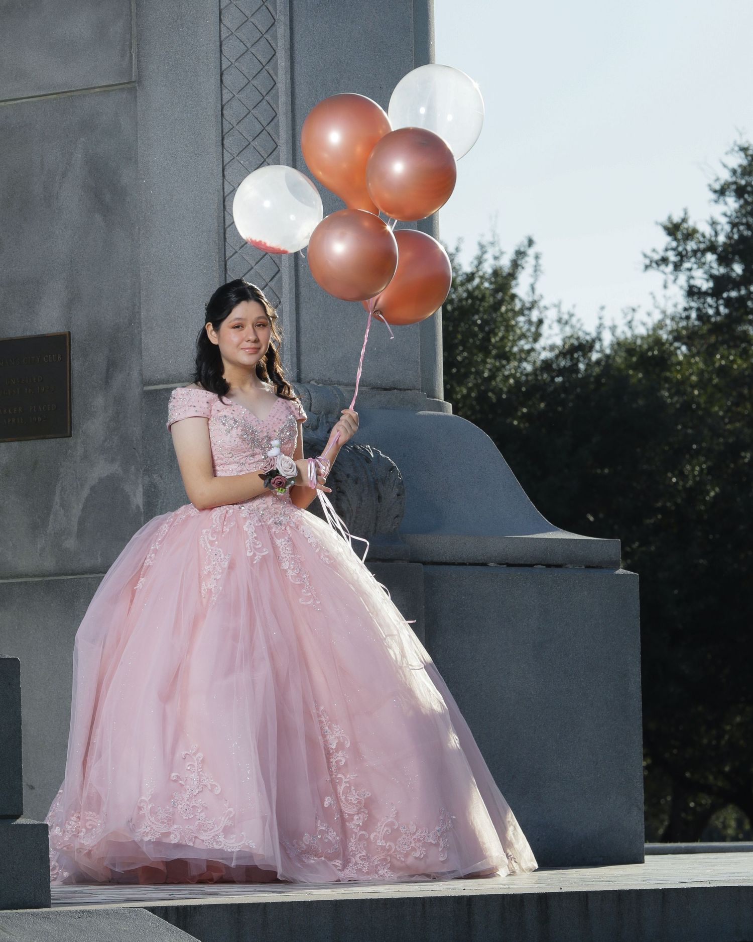 Elegant pink ball gown with lace details accessorized with rose gold and white balloons.