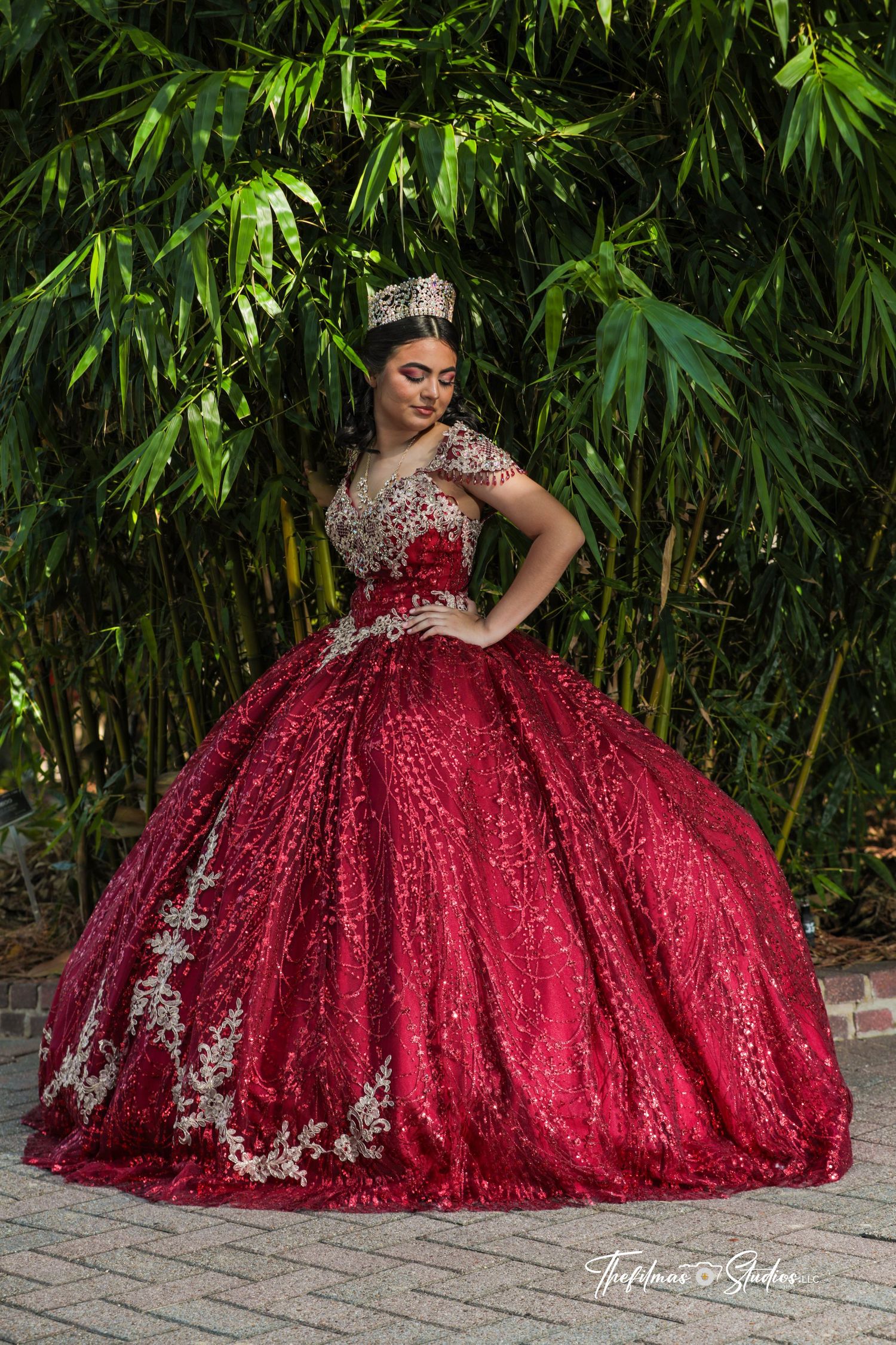 Stunning red and silver ball gown with intricate embroidery against bamboo garden backdrop.
