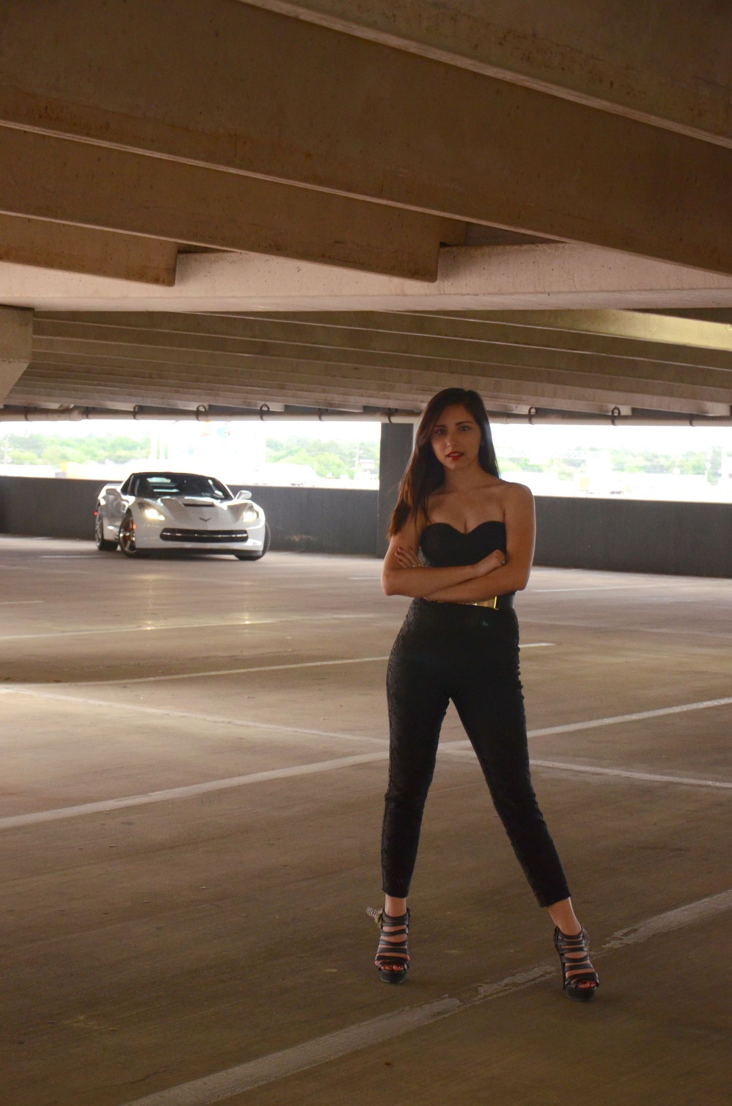 Urban fashion shoot in parking garage with sports car in background.
