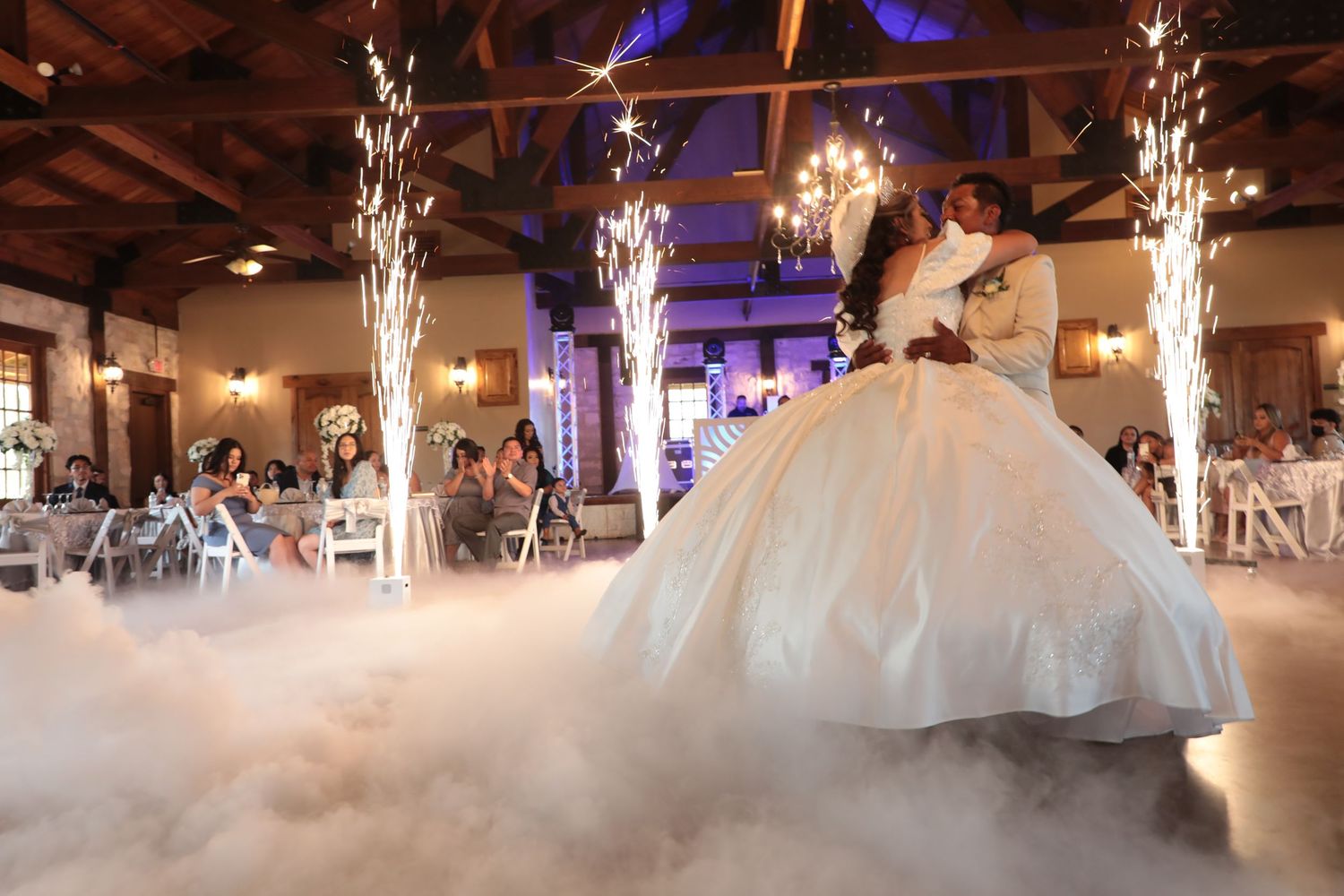 A dramatic first dance with fog effects and sparklers in an elegant reception venue.