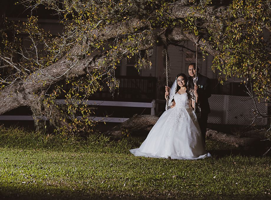 A dreamy bridal portrait captured at dusk beneath overhanging tree branches.
