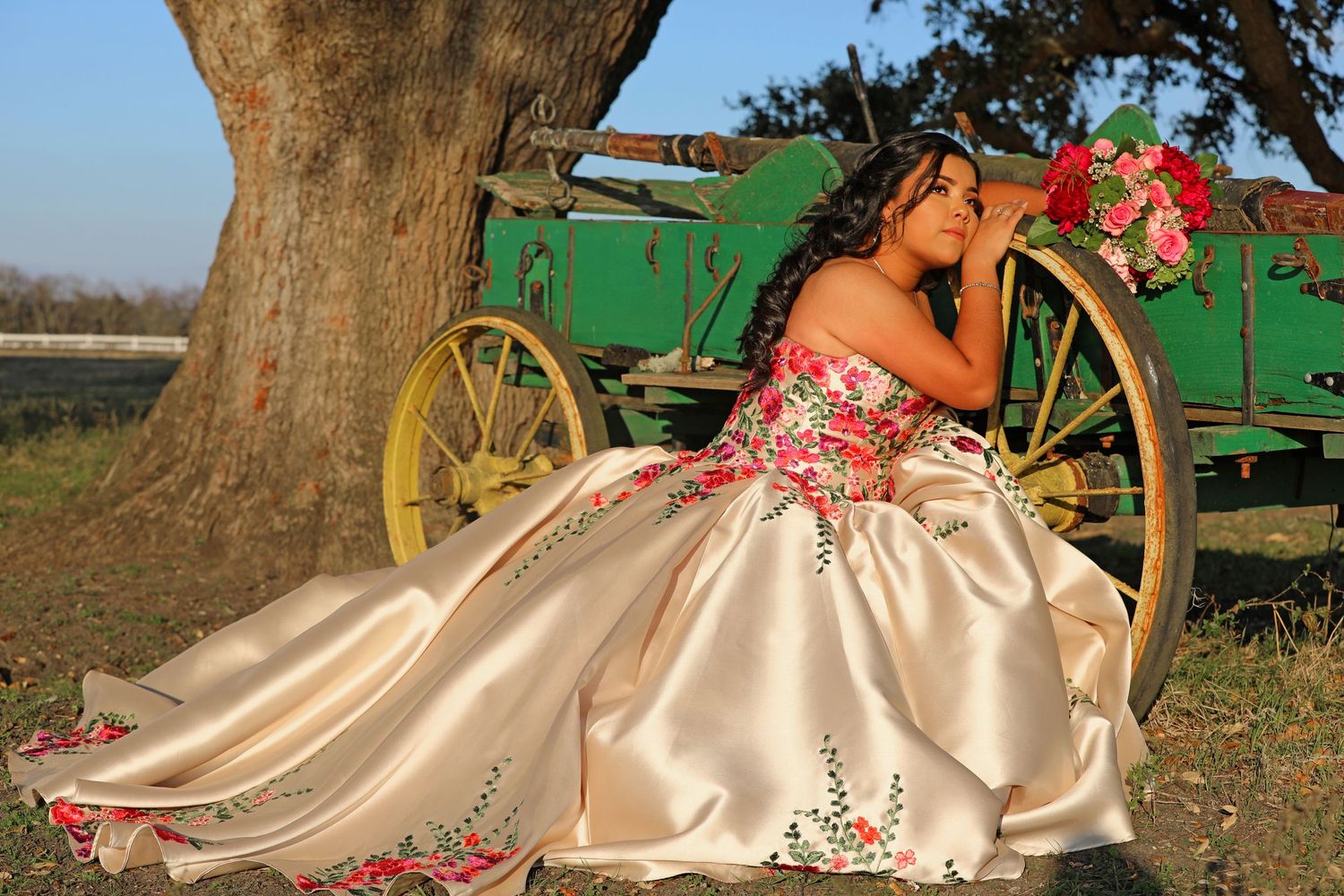 A elegant dress with floral embroidery photographed near a vintage green wagon.