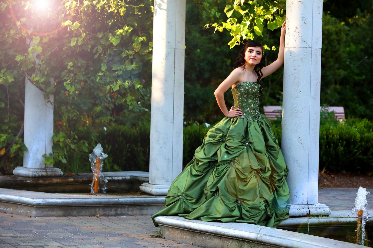 Emerald green ballgown with gathered details photographed between classic white columns.