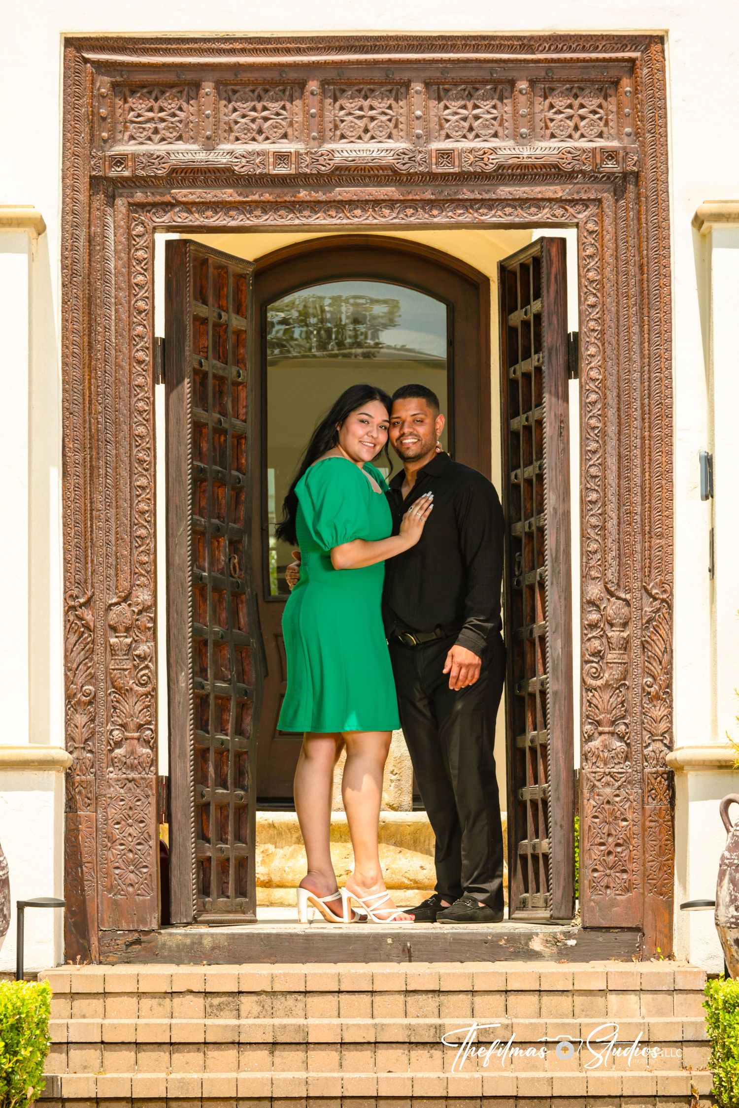 Couple poses in ornate doorway entrance during engagement photo session.