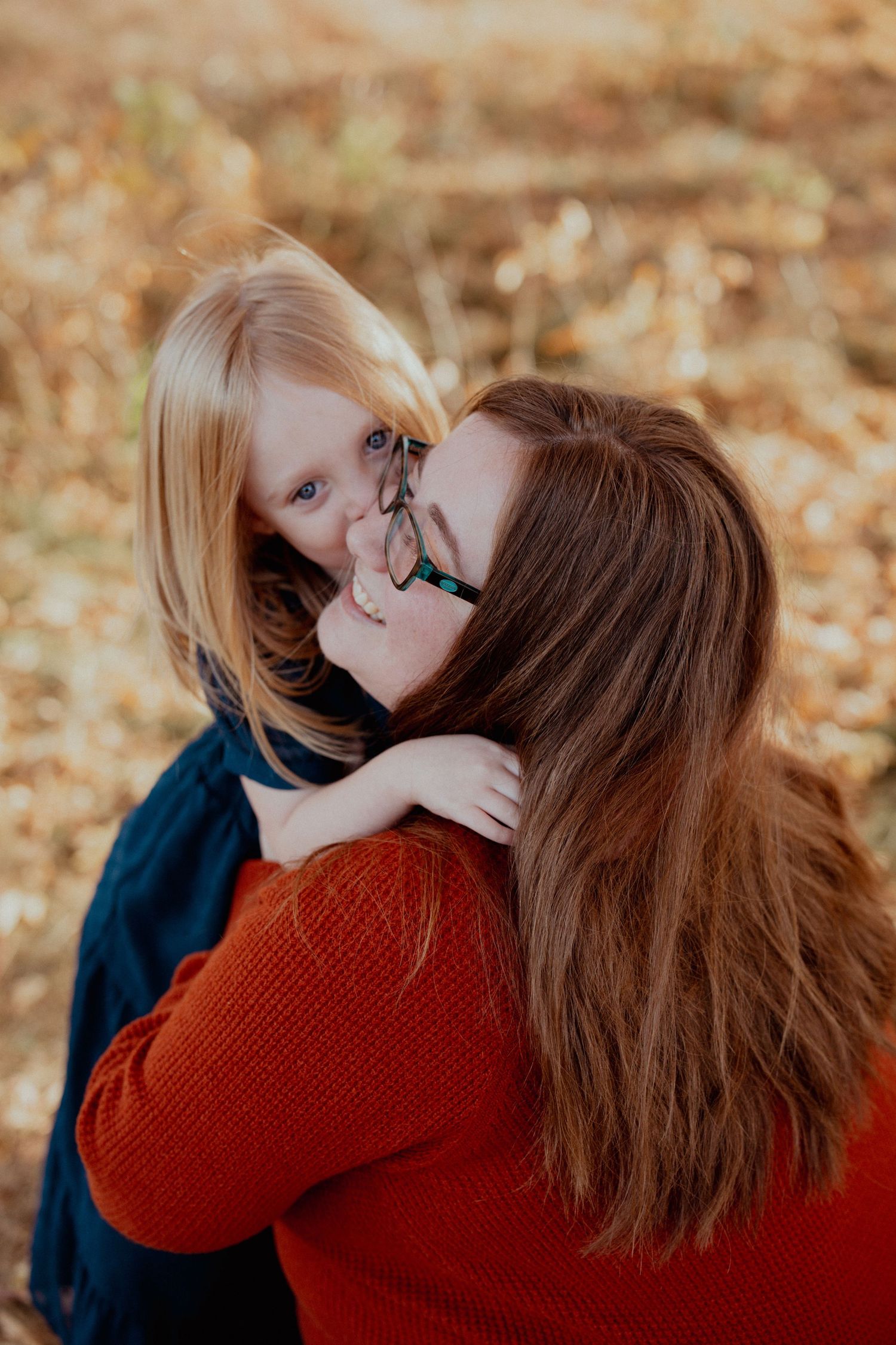 Candid family moment captured during autumn outdoor photo session.