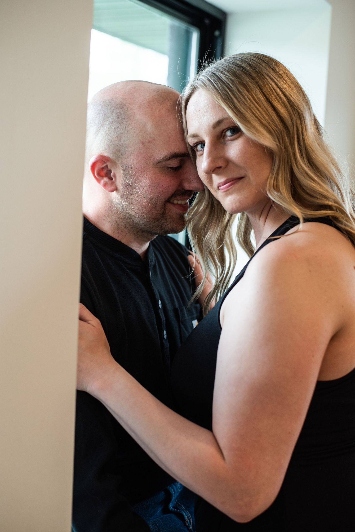 Intimate indoor portrait session showing tender moments between a couple.