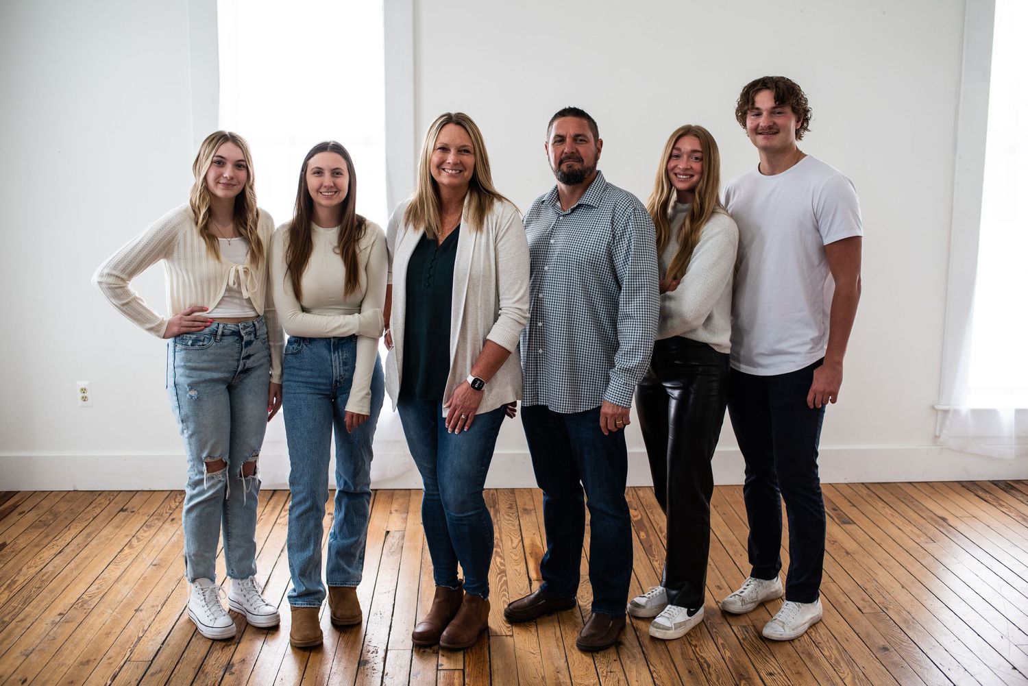 Group of family members posing together in a bright indoor setting.