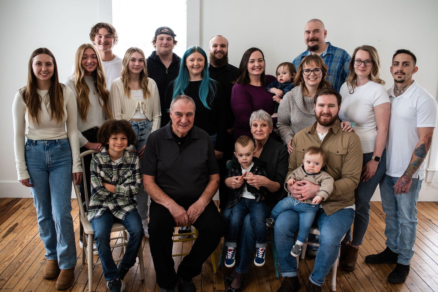 Extended family gathering with multiple generations posed together in casual attire.