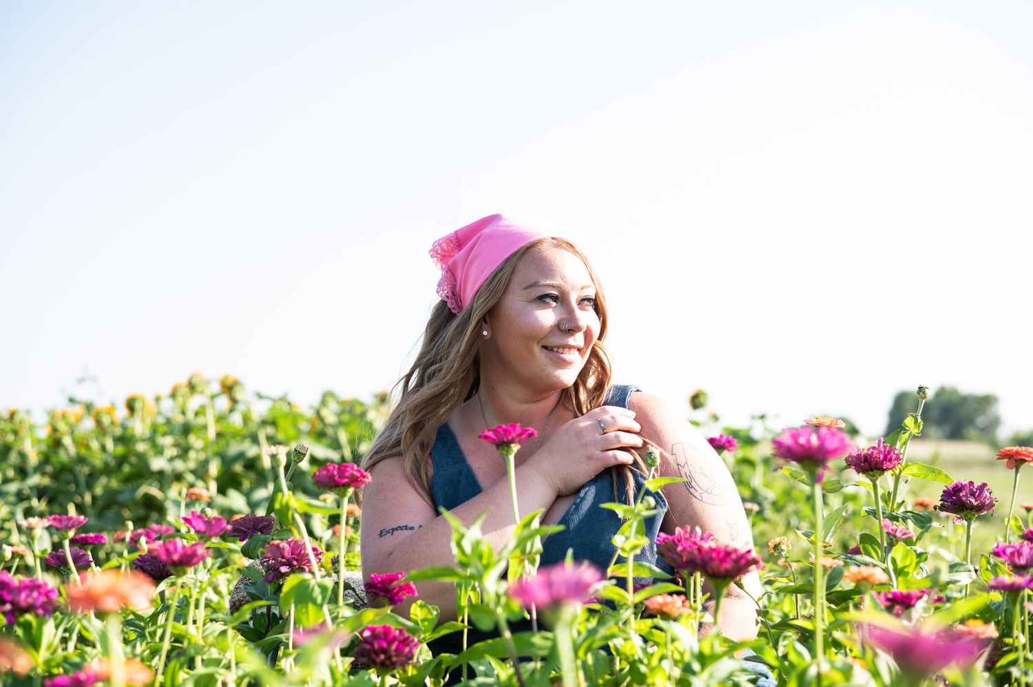 Summer portrait in a flower field with pink accessories and natural lighting.
