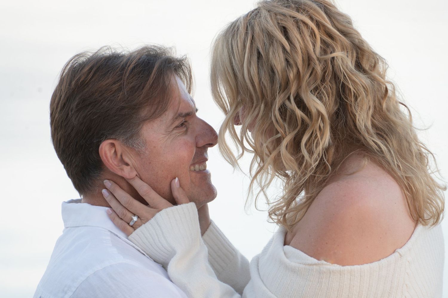 Close-up portrait of people in white clothing against bright background.