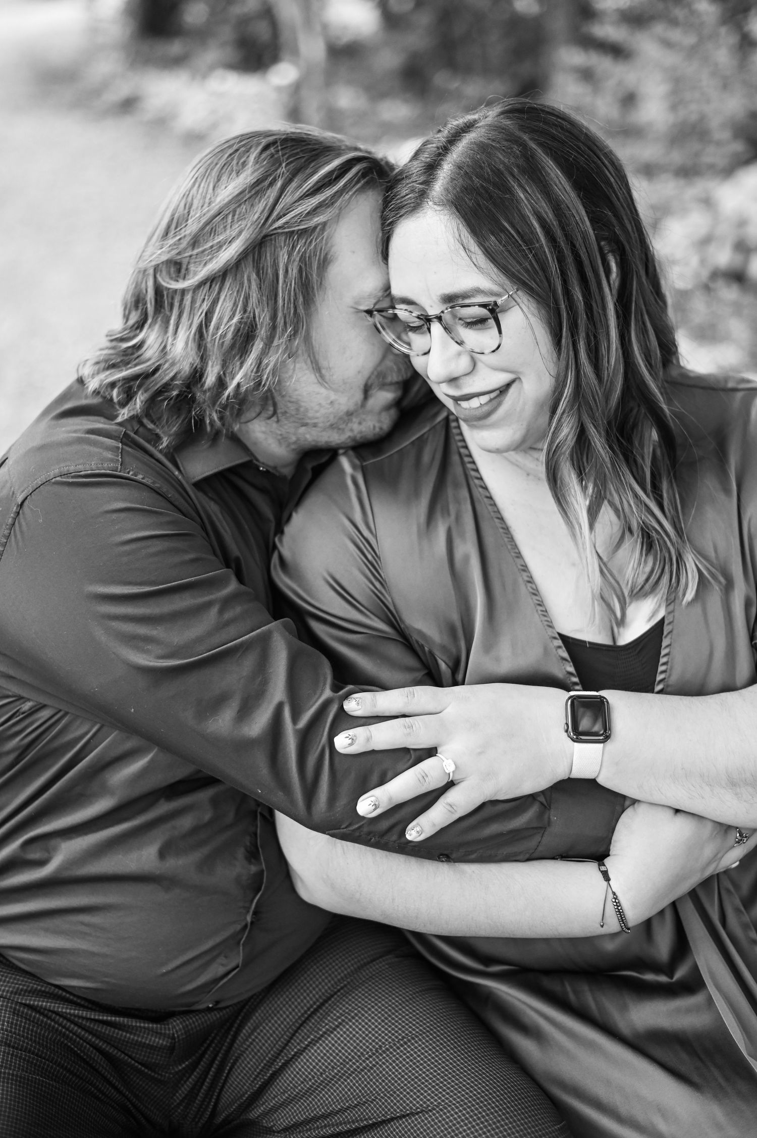 Black and white intimate portraits of a couple sharing tender moments outdoors.