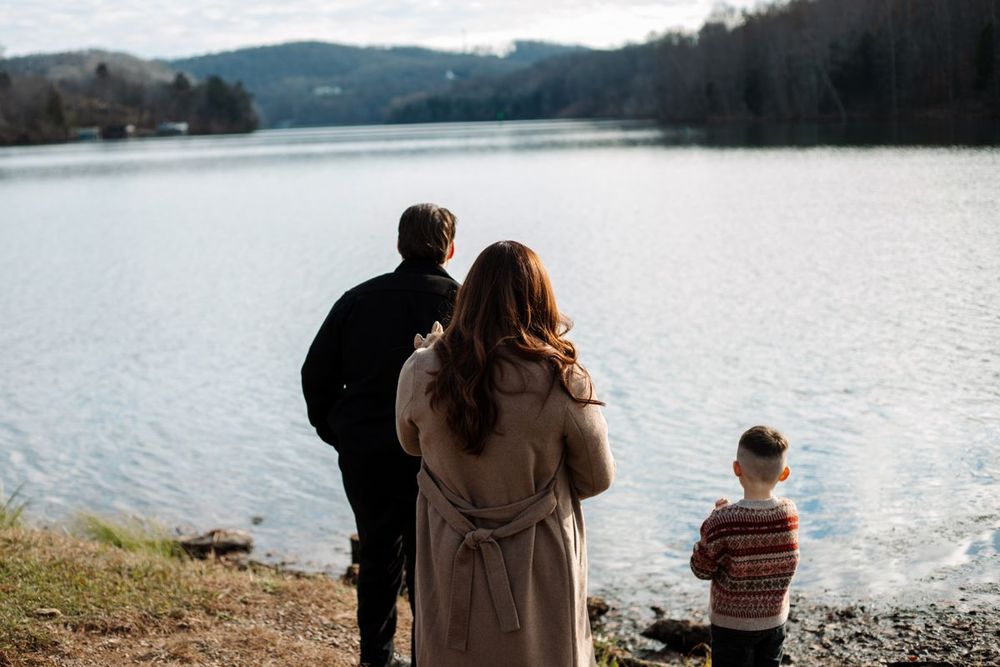 A family looking out over a mountain lake together