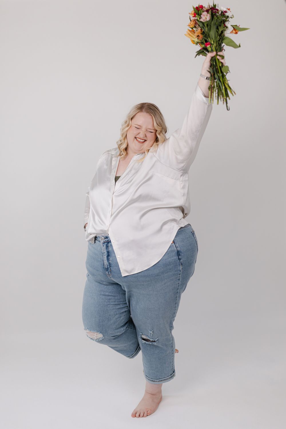 Charli celebrating with a bouquet of flowers held high