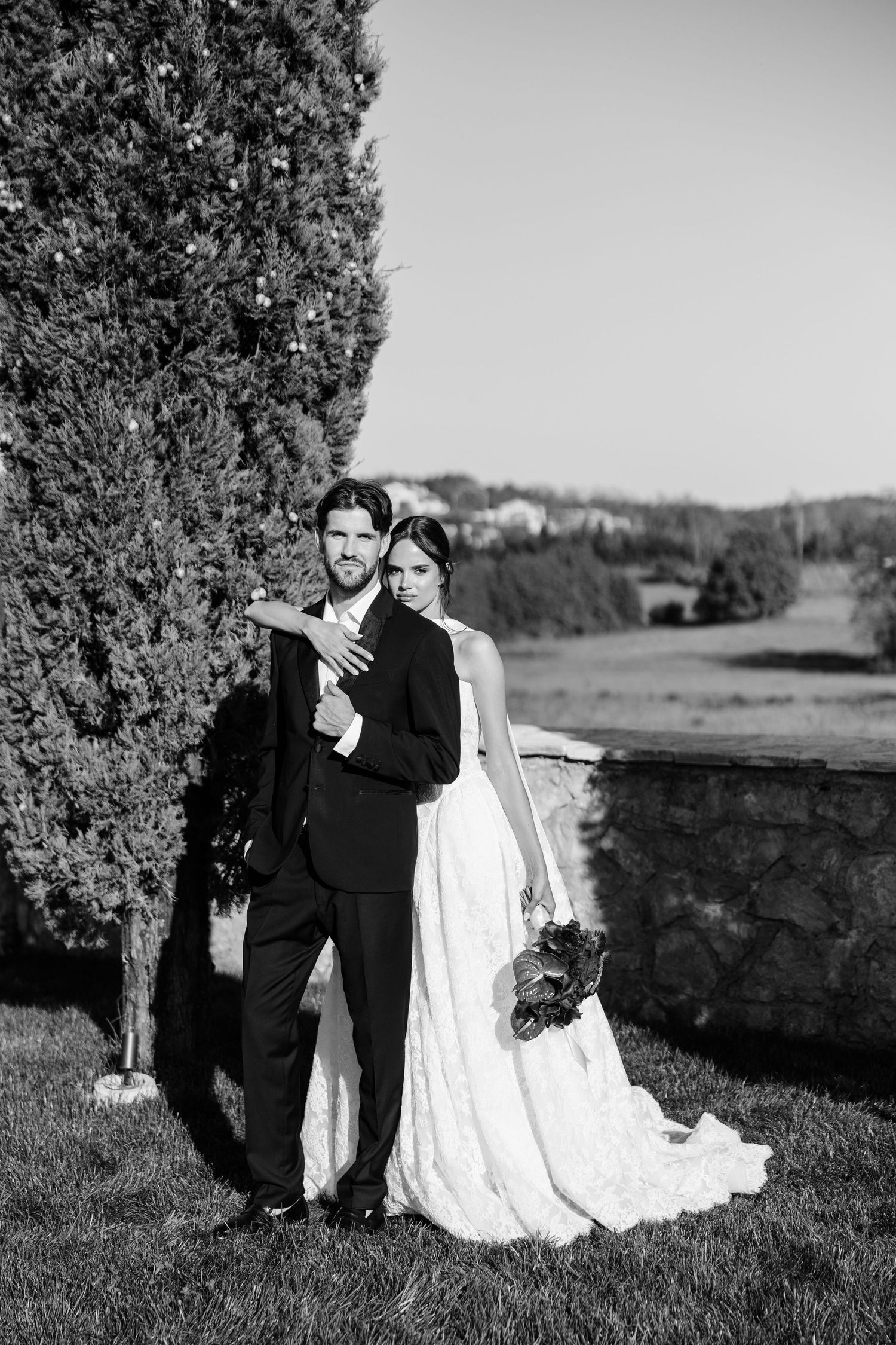 Bride and groom posing in black and white outdoor wedding portrait.
