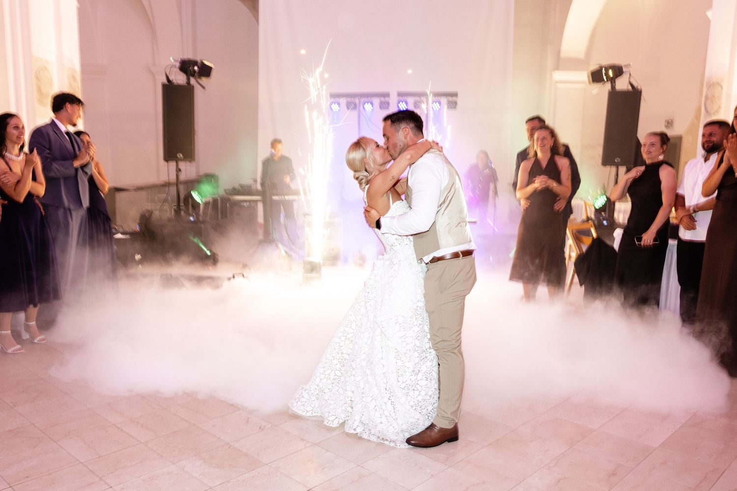 Newlyweds share romantic first dance surrounded by dry ice fog at wedding reception.
