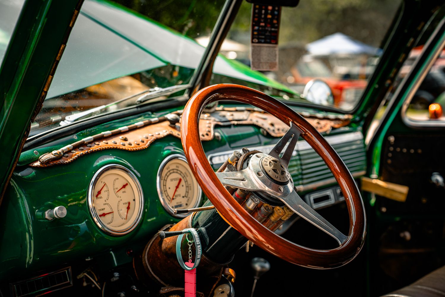 Vintage green car interior with wooden steering wheel and classic dashboard gauges at a car show. Southeastern Truck Nationals