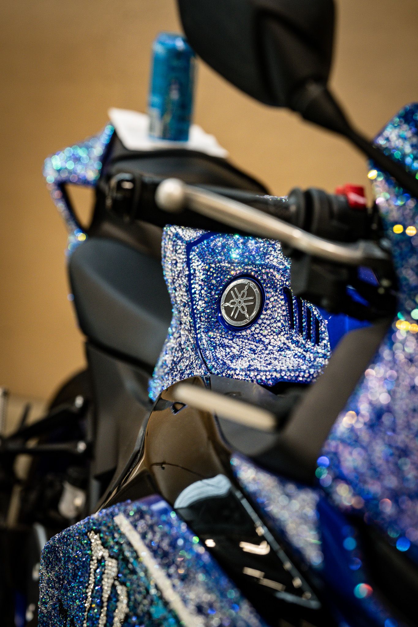 Close-up of a Yamaha motorcycle handlebar covered in blue rhinestone crystal custom decoration. Slammednuff