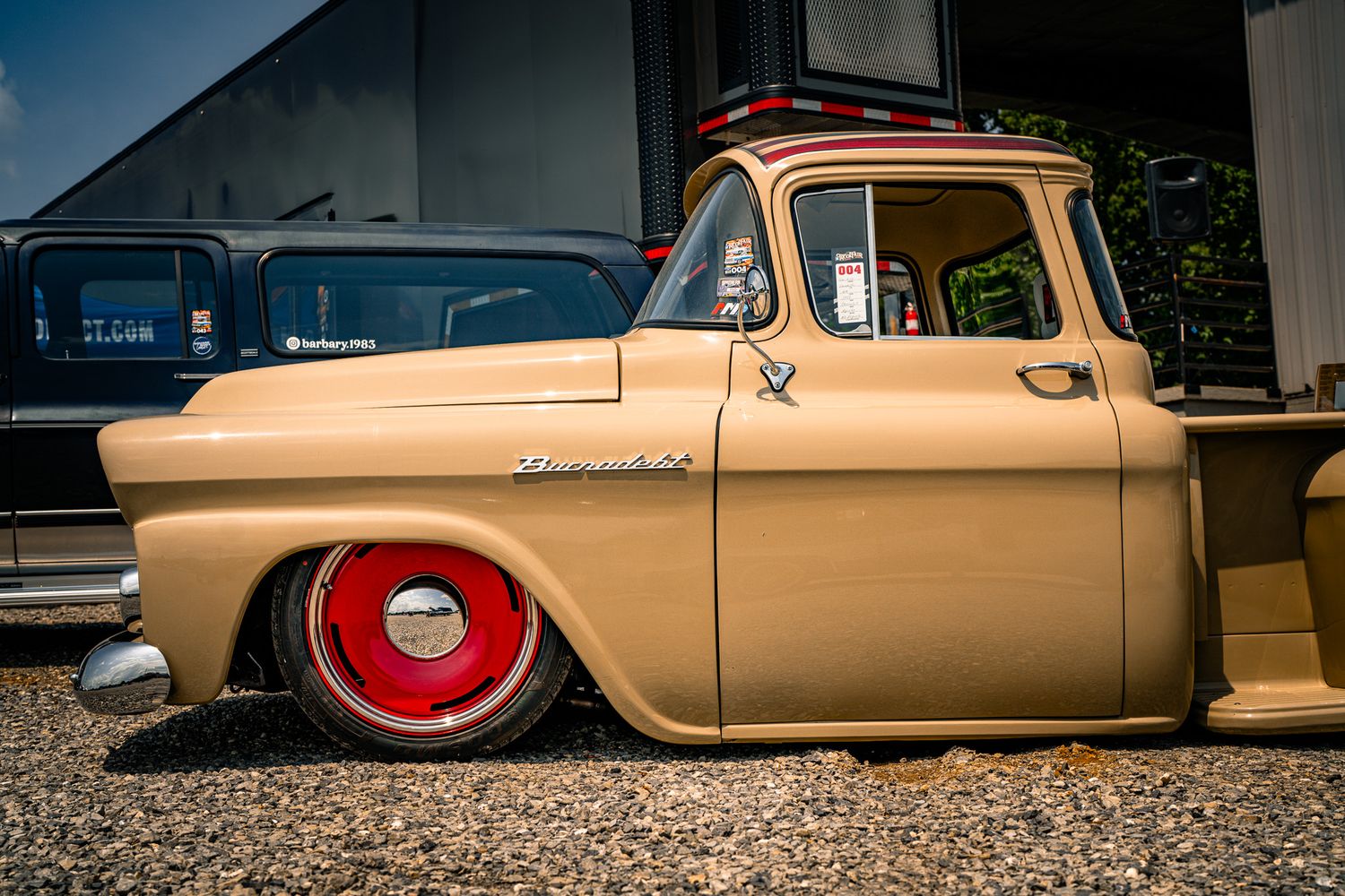 Gold lowered classic Chevrolet pickup truck with red wheels at an outdoor car show. GM Truck Fair. AMD
