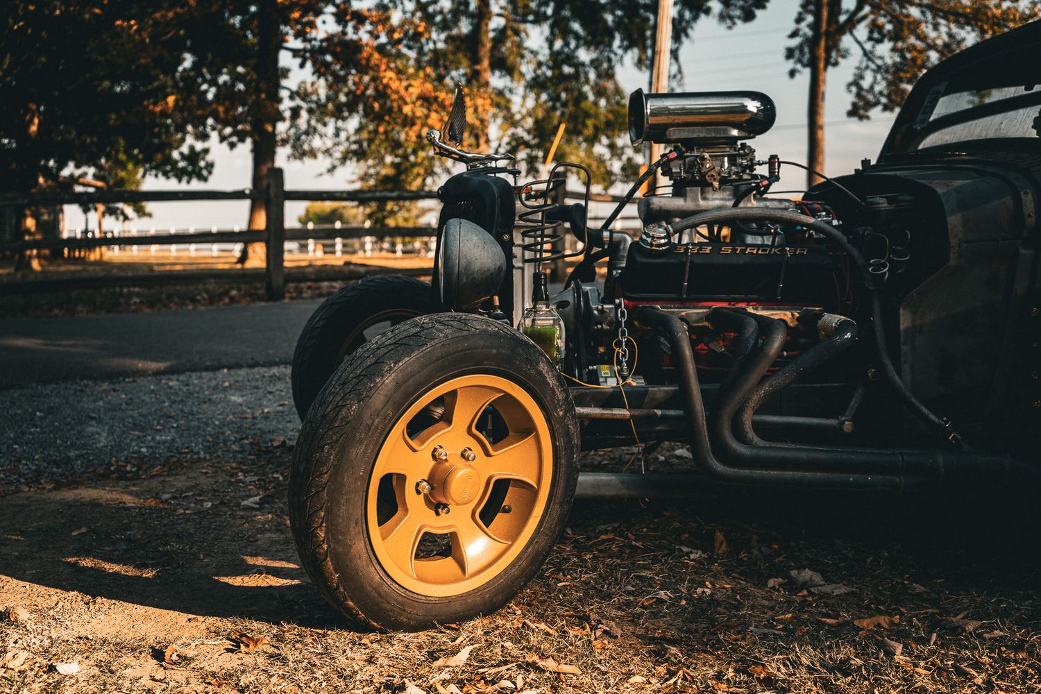 Vintage hot rod rat rod with yellow wheels and exposed engine in autumn setting. Redneck Rumble