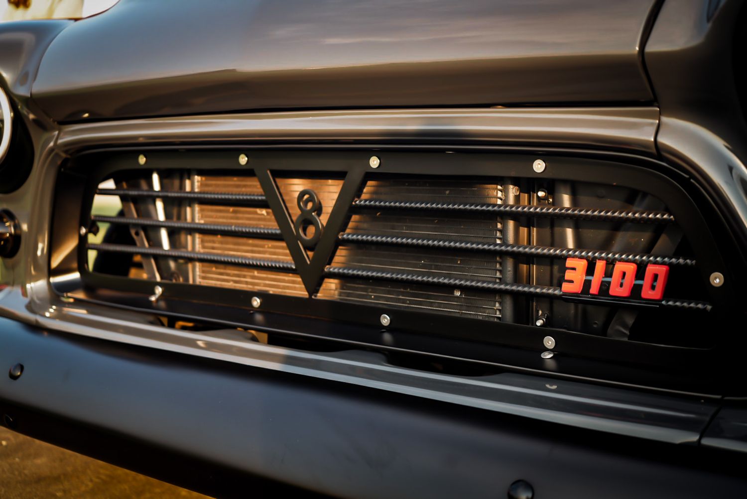 Custom truck grille with V-emblem, LED light bar, and red 3100 badge in dark finish. Cars & Christ Nashville