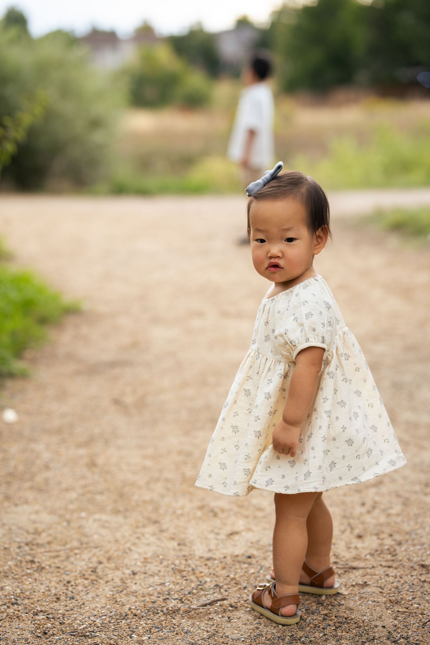 Baby looking backwards on path.