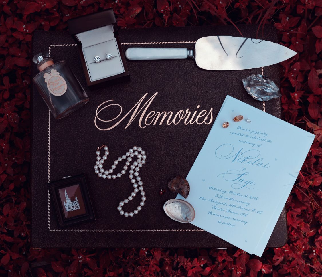 A bridal flat lay featuring various trinkets spread out over a photo album titled 