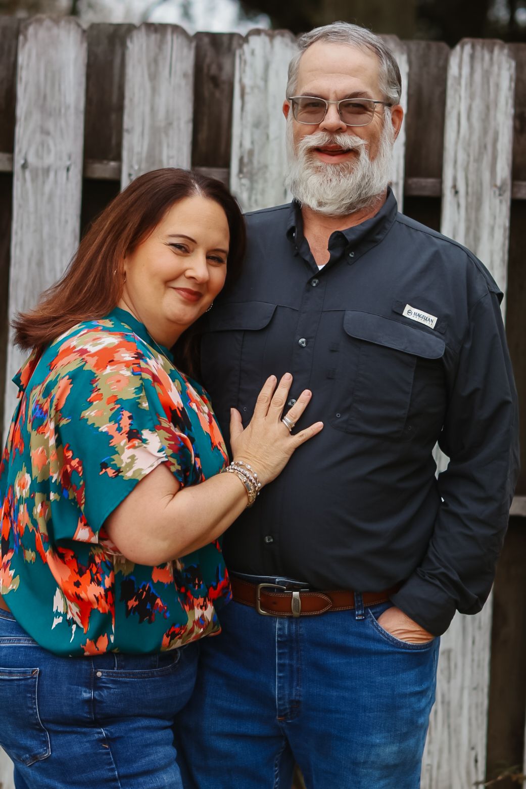 A heartwarming family portrait session against a rustic wooden fence background.