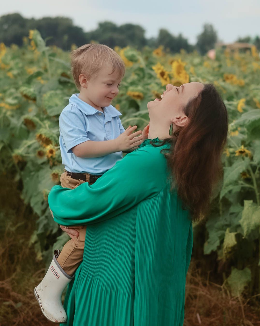 A joyful moment between parent and child in a sunflower field.