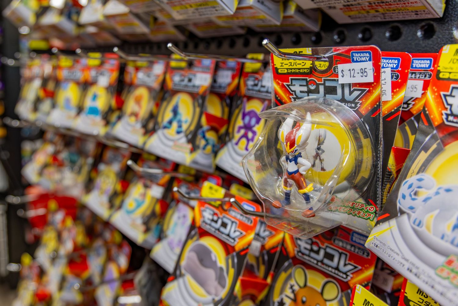 Shelves stocked with colorful Pokemon toy figures in packaging at a retail store.