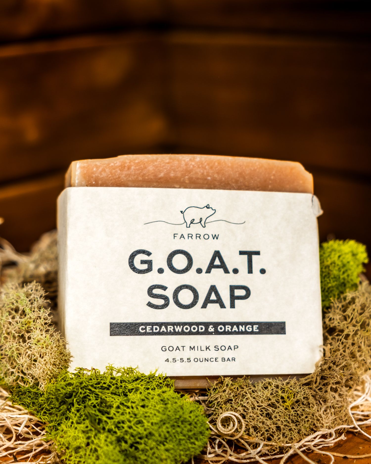 Bar of Farrow G.O.A.T. Cedarwood and Orange goat milk soap resting on decorative moss.  Product photography. Branding materials. Brands.