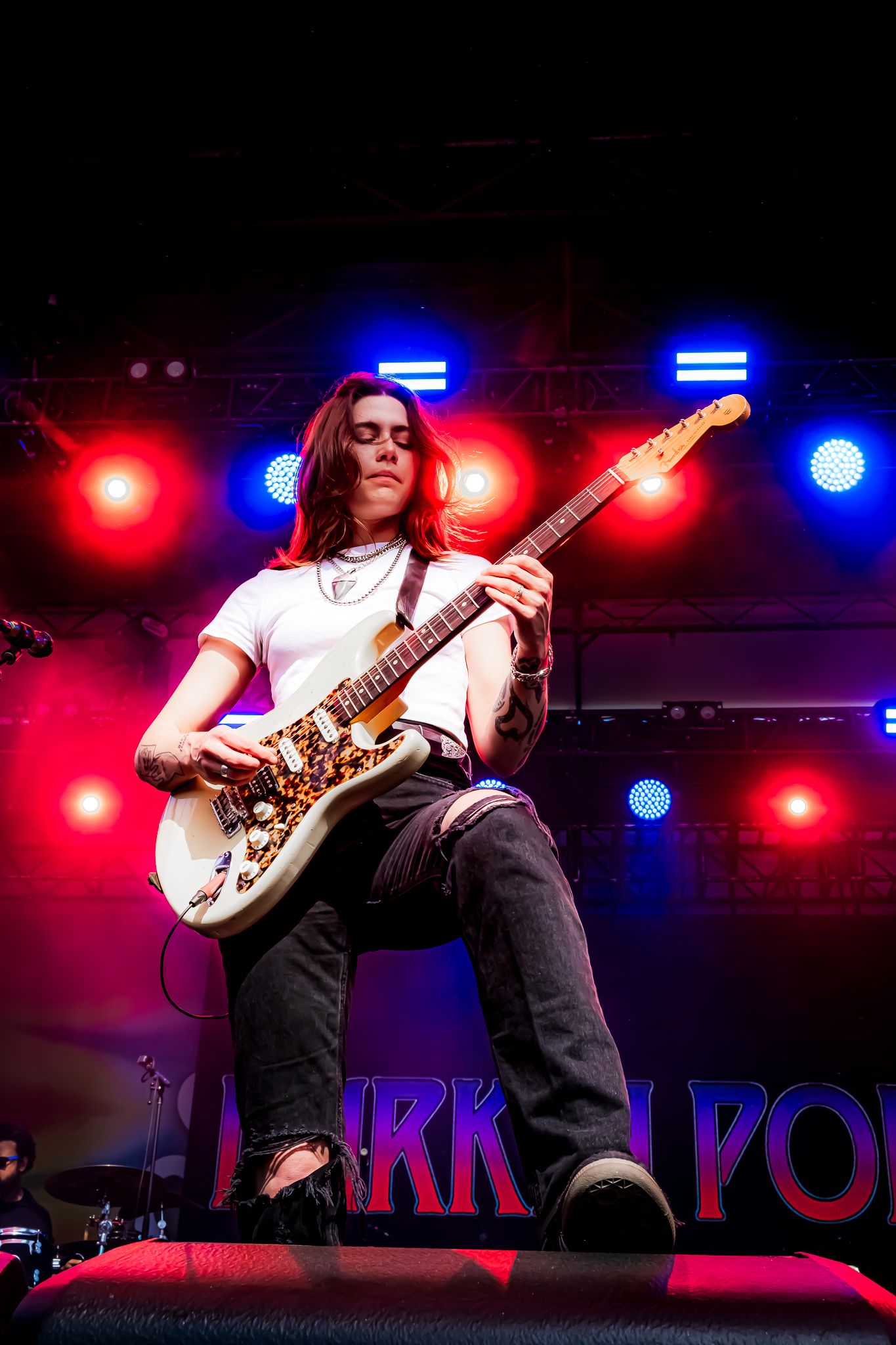 Female guitarist performing on stage with white Fender guitar under red and blue stage lights.
WAB Photography Co. specializes in documentar