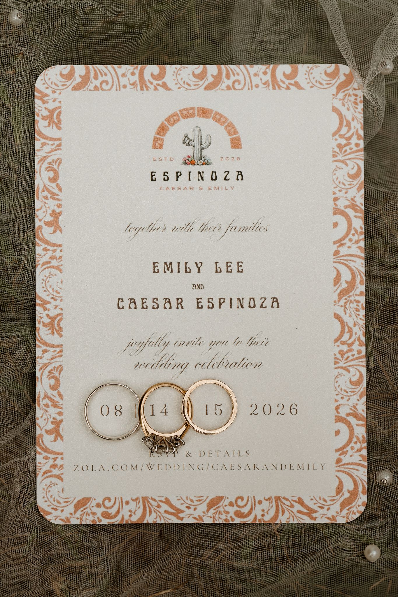 Wedding invitation for Emily Lee and Caesar Espinoza dated 08.14.15.2026, displayed with two gold wedding rings.