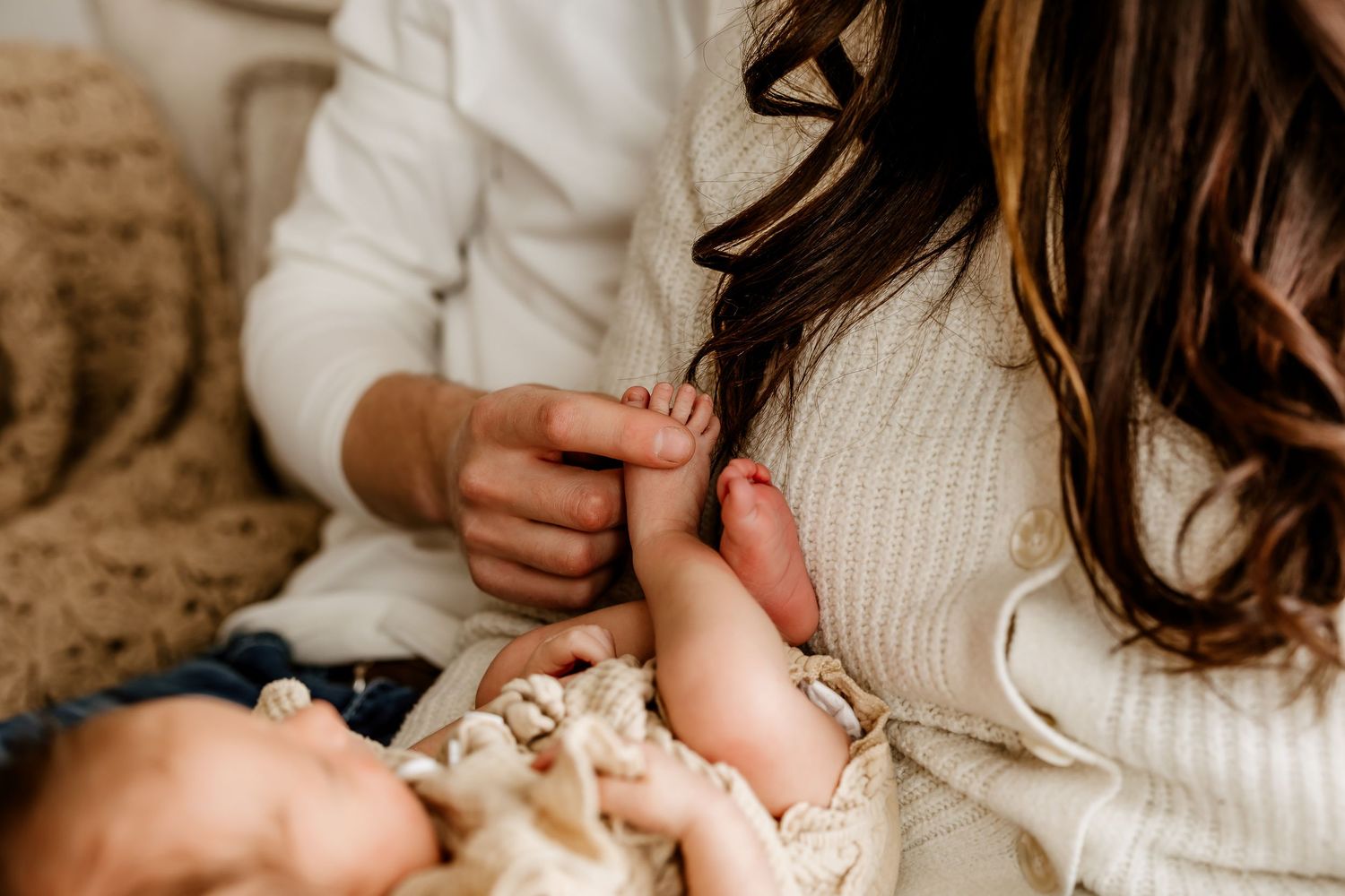 Close-up of a mother gently holding her newborn baby's tiny feet with tender care.