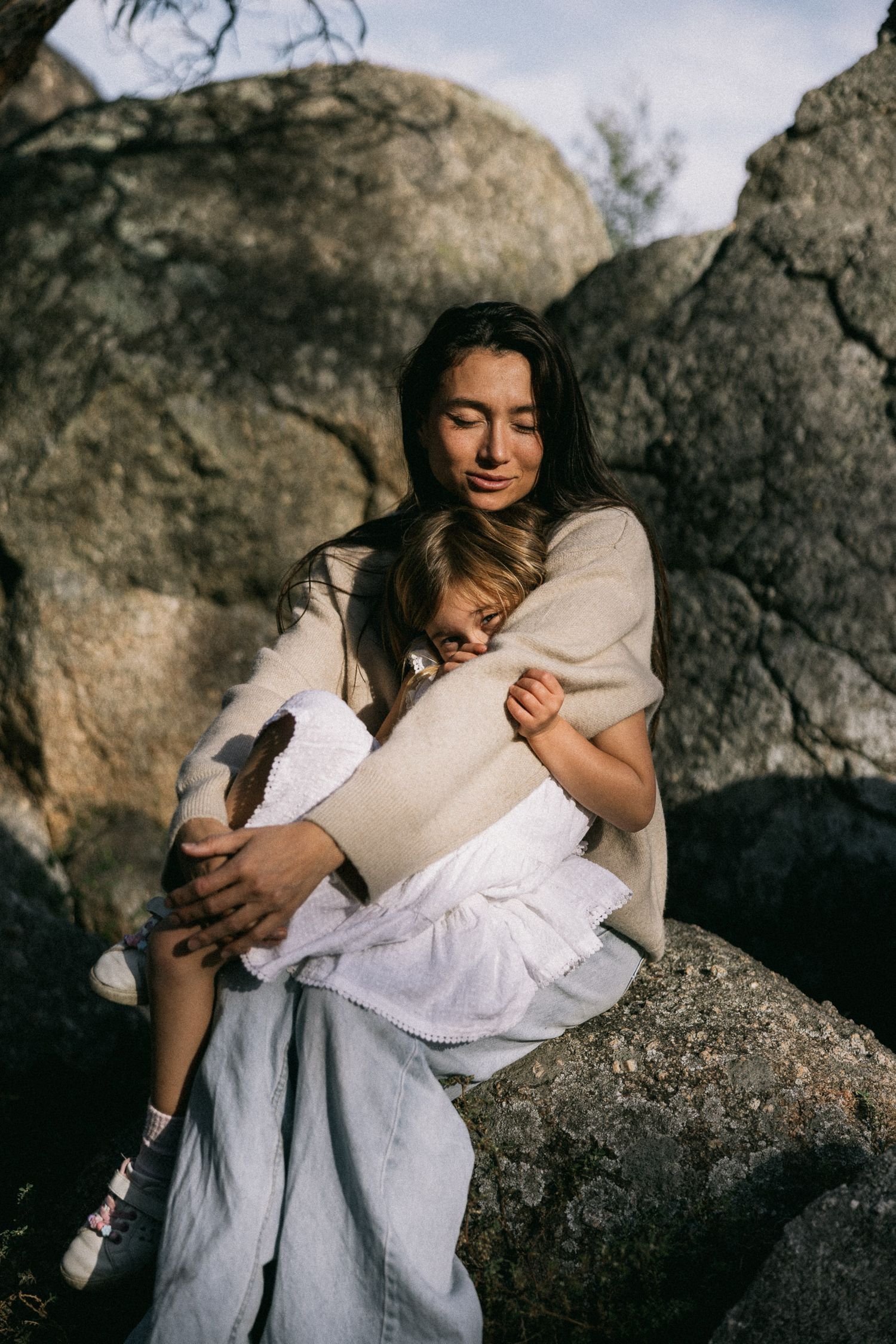 A mother hugs her daughter on a sunny day at You Yangs Regional Park.