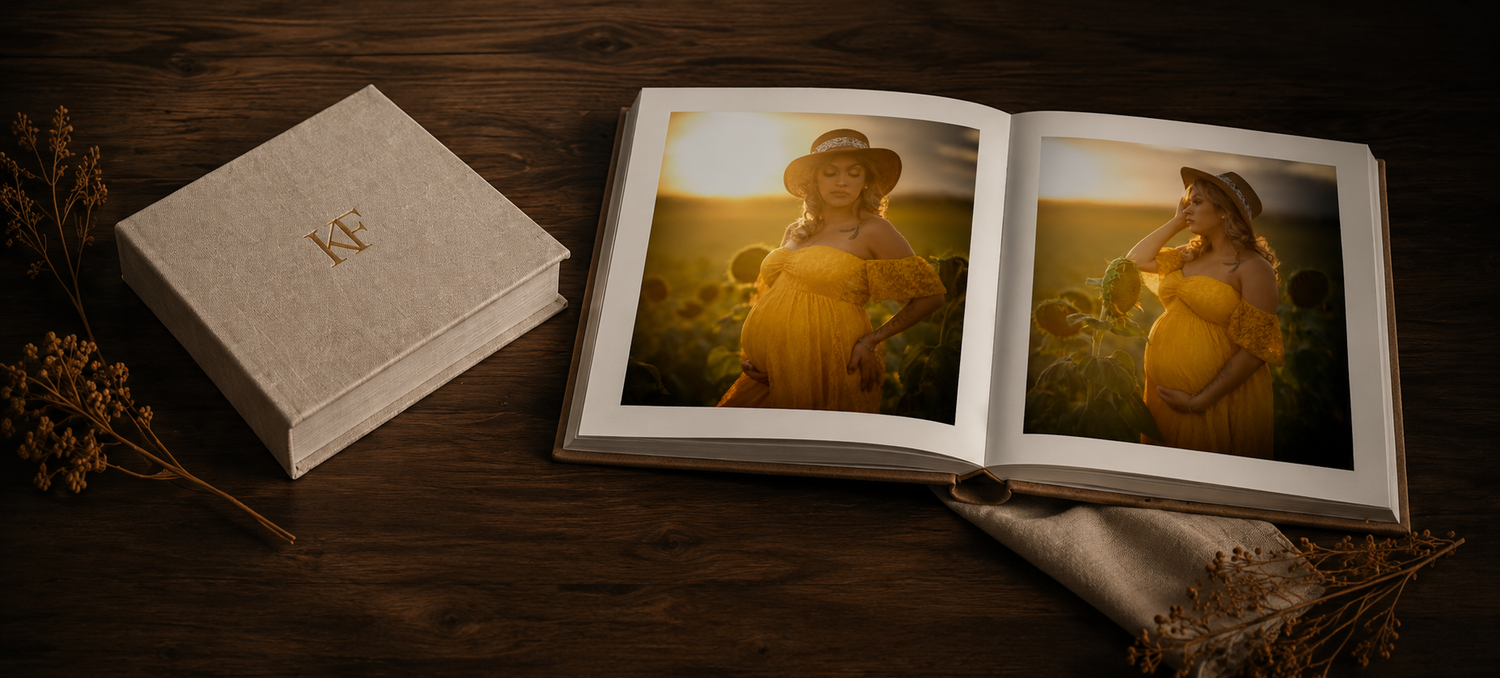 An open maternity photo album beside a linen box displayed on a wooden table.