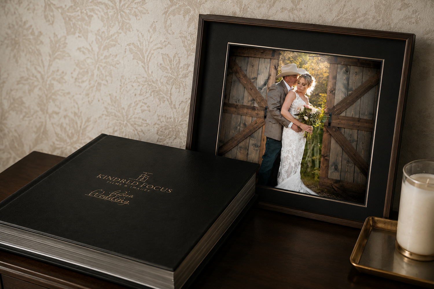 Wedding photo album and framed portrait of bride and groom displayed on wooden table.
