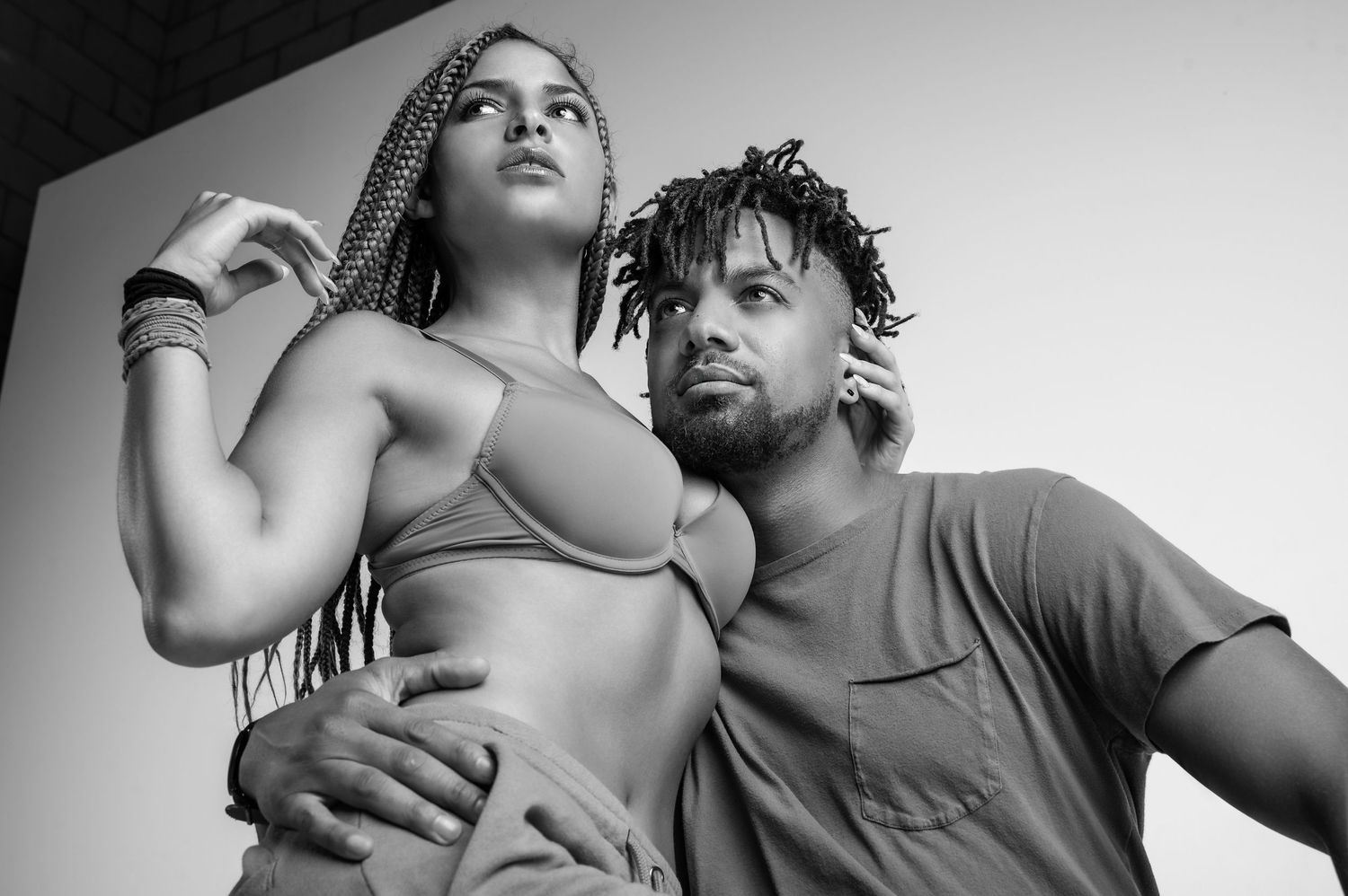 Black and white portrait of stylish couple posing together in urban setting.