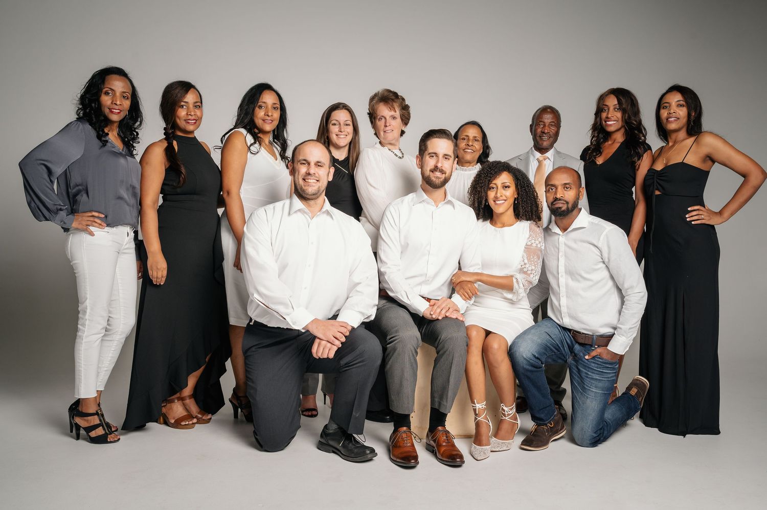Professional group portrait of diverse business team in formal attire on studio background.