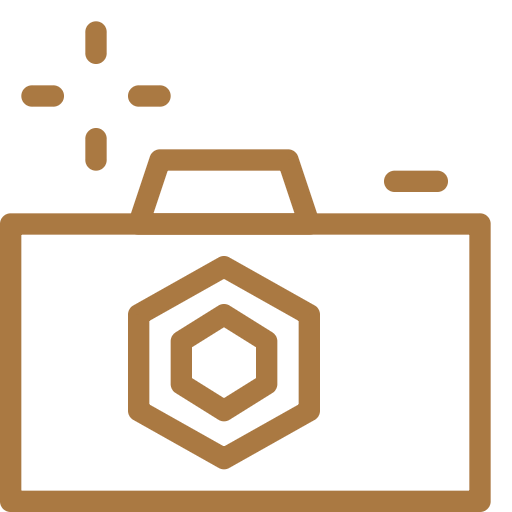 A golden brown camera icon with a hexagon lens design on a white background.