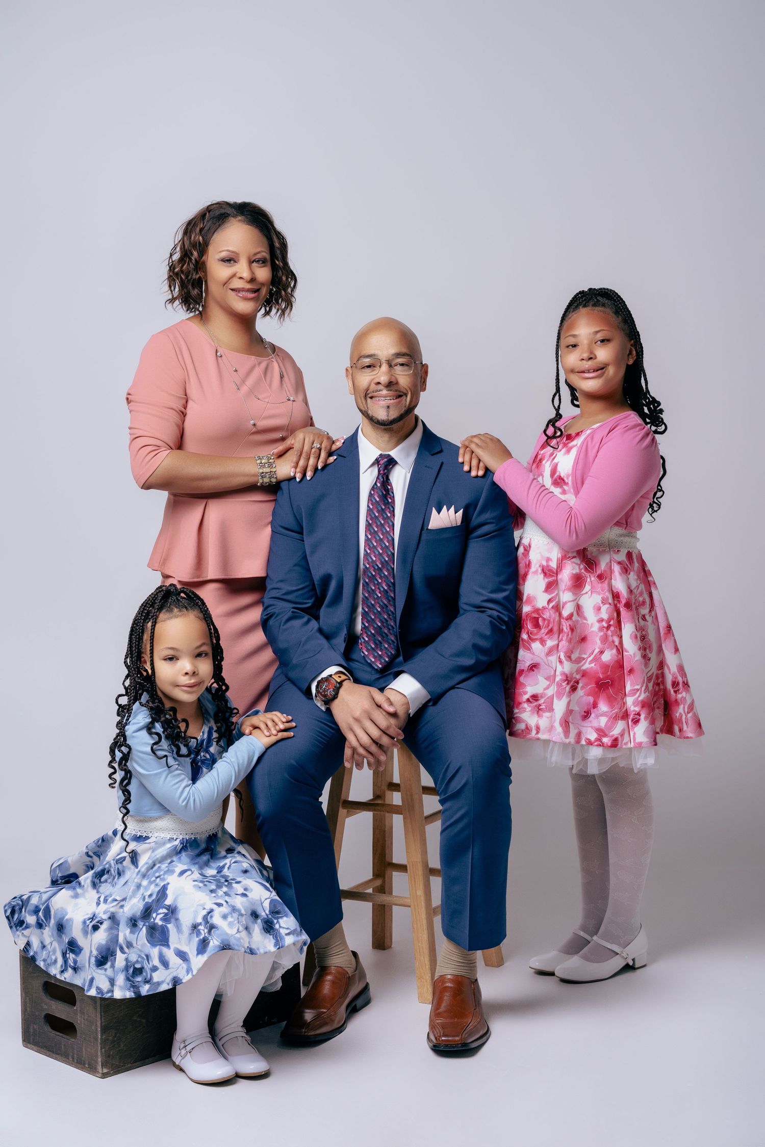 African American family of four in formal attire posing for elegant studio portrait photography.