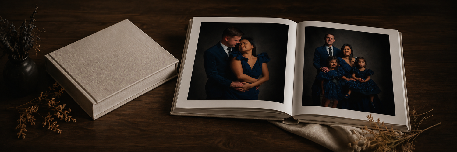 Open family photo album displaying professional portraits beside a linen-covered keepsake box.