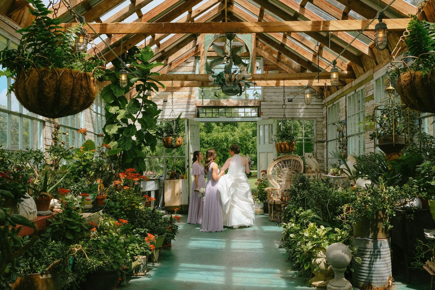Bride in a greenhouse surrounded by lush tropical plants during a romantic wedding celebration.