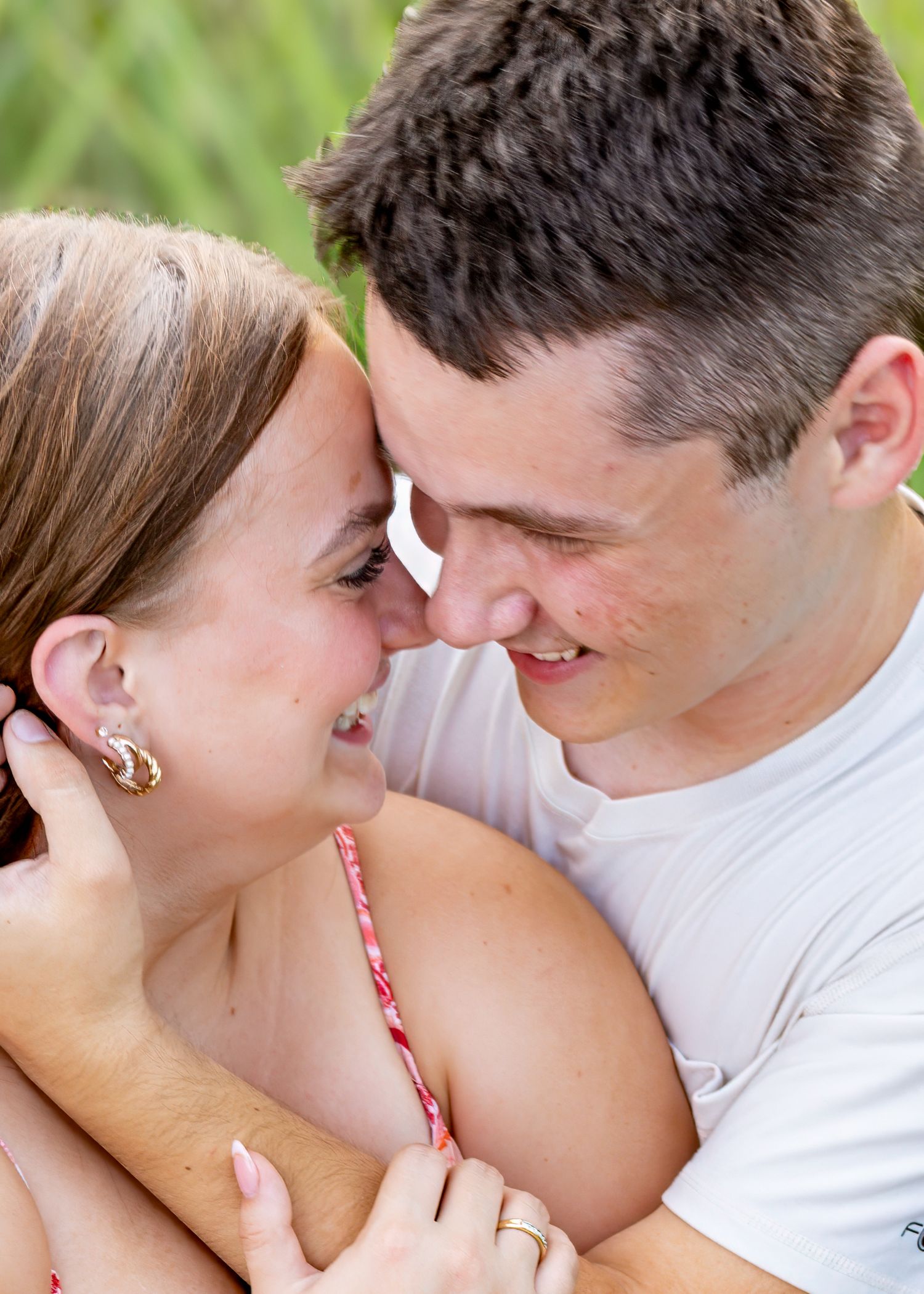 Young couple sharing an intimate romantic moment, touching foreheads and smiling closely.